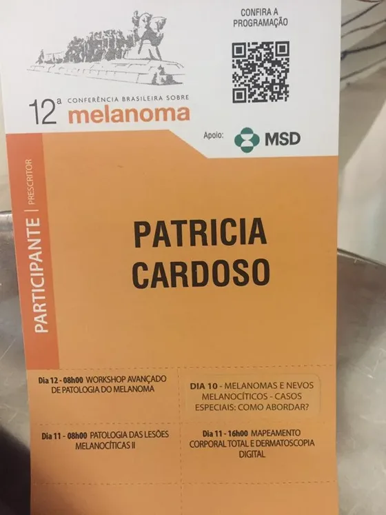 Crachá laranja de participante da 12ª Conferência Brasileira sobre Melanoma.
